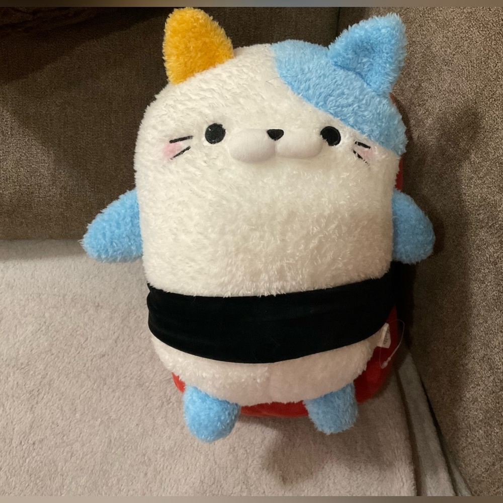 Takashoji; Plush/stuffed cat with black belt straped Sushi backpack on back.